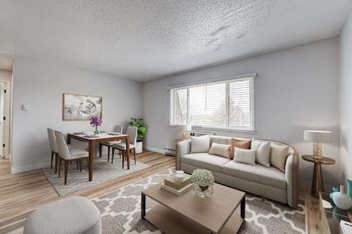 A well-lit living room with a dining table and a couch at The Hampton Meadows Apartments,Des Moines, Iowa