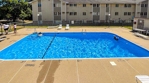 A large blue swimming pool in front of a building at The Ridges Apartments, IA, 50315