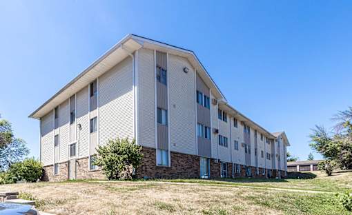 A modern building with a flat roof and a stone base at The Ridges Apartments, Des Moines, IA,  50315