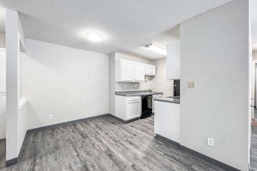 A kitchen area with white cabinets and a dishwasher at The Ridges Apartments, Des Moines, IA,  50315