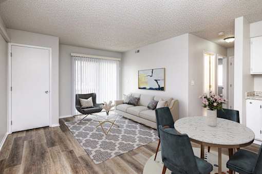 A living room with a white couch, a grey rug, and a round table with chairs.at Fish Creek, Norwalk, IA  