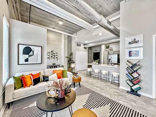 A modern living room with a grey couch, a coffee table, and a bookshelf.at Level, Iowa, 50309