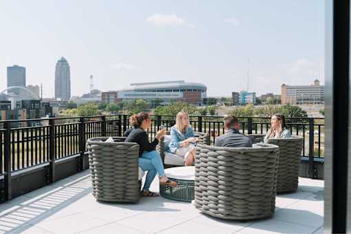 A group of people are sitting on a rooftop terrace.at Level, Des Moines  