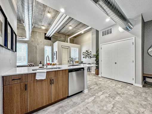 A modern kitchen with wooden cabinets and a white countertop.at Level, Des Moines  