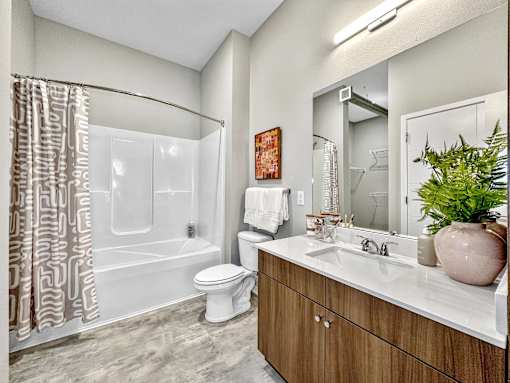 A bathroom with a toilet, sink, and shower.at Level, Des Moines, IA 50309  