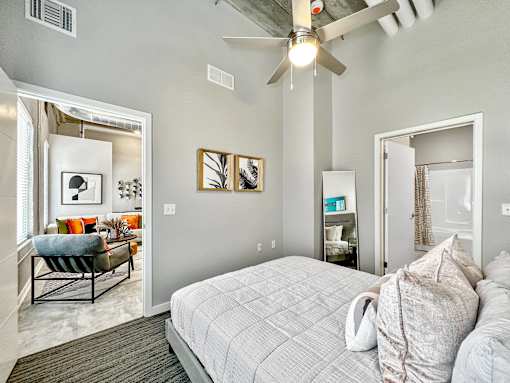 A bedroom with a bed, a chair, and a ceiling fan.at Level, Des Moines, IA  