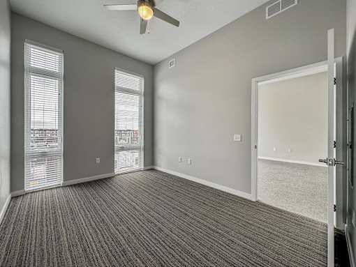 A room with a ceiling fan and carpeted floor.at Level, Des Moines, IA 50309  