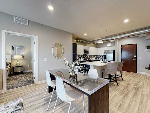 a dining room and kitchen with a table and chairs at Linc, Des Moines  