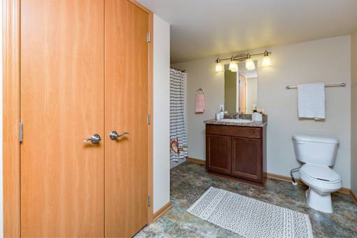 a bathroom with a wooden door and a toilet and a sink at Melbourne Apartments, Georgia