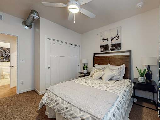 a bedroom with a bed and a ceiling fan at Melbourne Apartments, IA, 50320