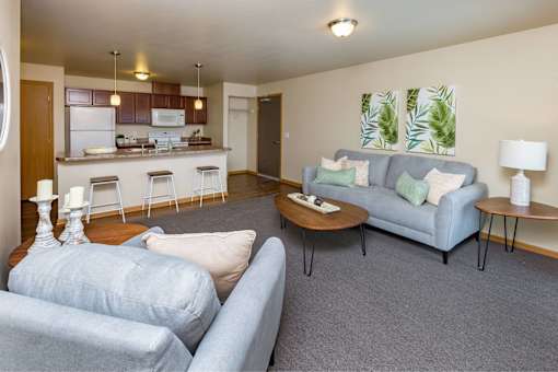 a living room with couches and a table at Melbourne Apartments, Des Moines, IA