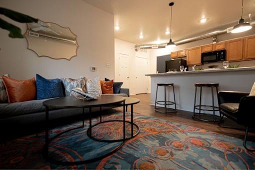 a living room and kitchen with a couch and a table at Melbourne Apartments, Des Moines