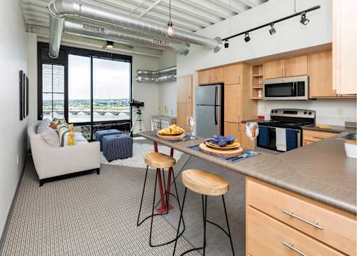 an open kitchen and living room with a large counter top  at Eagle View Lofts, Des Moines, IA