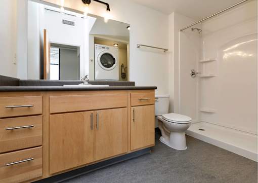 a bathroom with a toilet and a sink and a mirror at Eagle View Lofts, Des Moines, IA, 50309