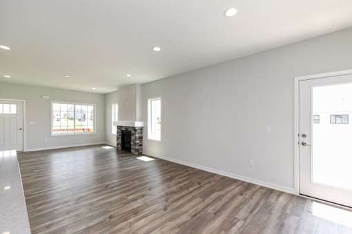A large empty room with wooden floors and white walls. at Two Rivers Home Rentals, West Des Moines, IA 50266