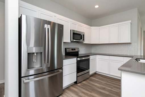 a kitchen with a stainless steel refrigerator at Two Rivers Home Rentals, West Des Moines, IA