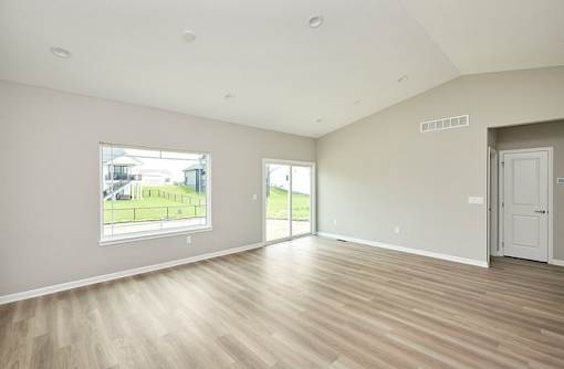 an empty living room with a large window and a door at Two Rivers Home Rentals, Iowa