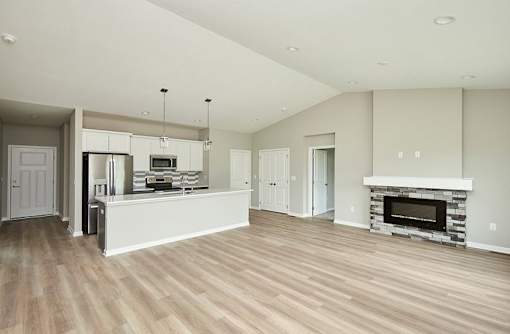 an empty living room with a kitchen and a fireplace at Two Rivers Home Rentals, Iowa