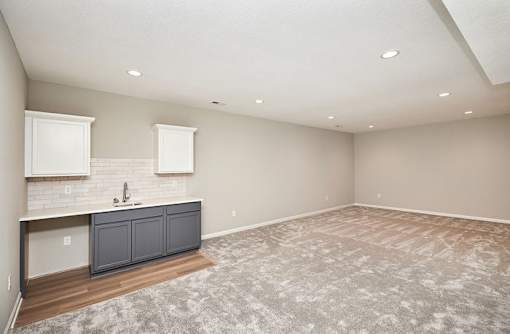 an empty living room with a sink and a kitchen at Two Rivers Home Rentals, West Des Moines