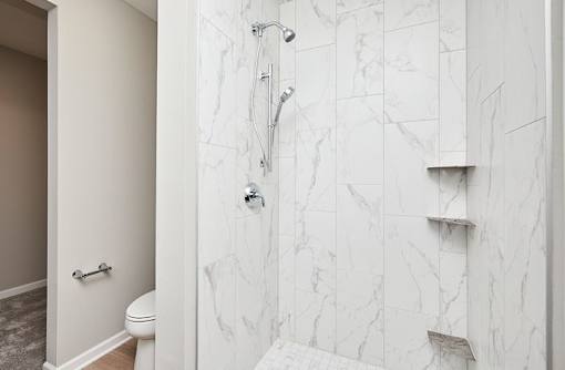 A white bathroom with a marble shower. at Two Rivers Home Rentals, West Des Moines, IA 50266