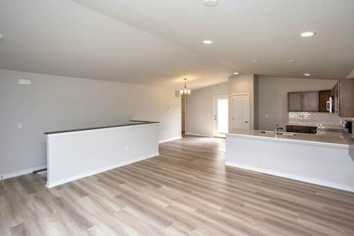 an empty kitchen and living room with a counter top at Two Rivers Home Rentals, West Des Moines, IA 50266