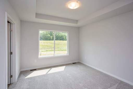 A room with a large window and a carpeted floor. at Two Rivers Home Rentals, Iowa