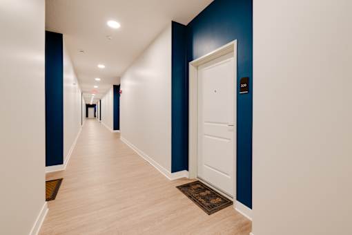 A hallway with blue walls and a white door.