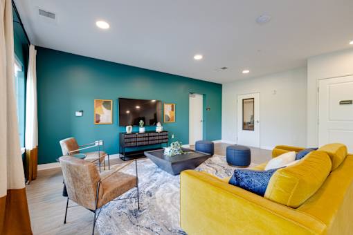 A living room with a yellow couch and a television.