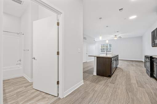 A white door is open to a kitchen area.