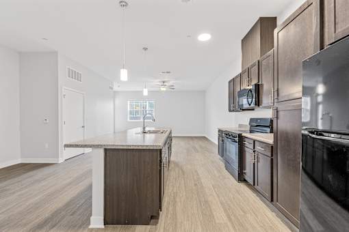 A modern kitchen with dark wood cabinets and stainless steel appliances.