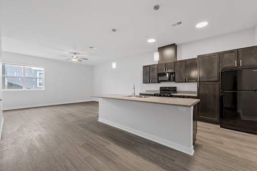 A kitchen with a white island and dark brown cabinets.
