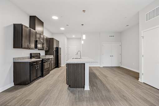 A kitchen with dark brown cabinets and a white island.