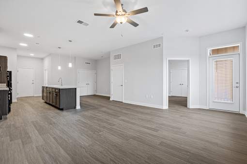 A spacious room with a ceiling fan and lighting fixtures.