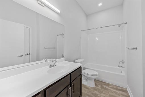 A white bathroom with a sink, toilet, and bathtub.