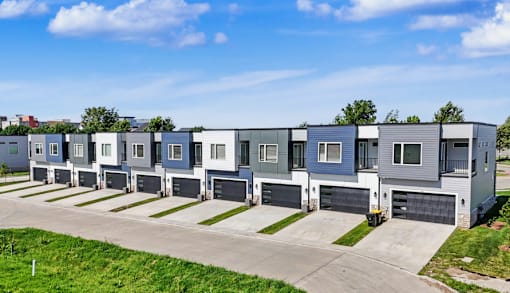 A row of modern houses with garages in front.