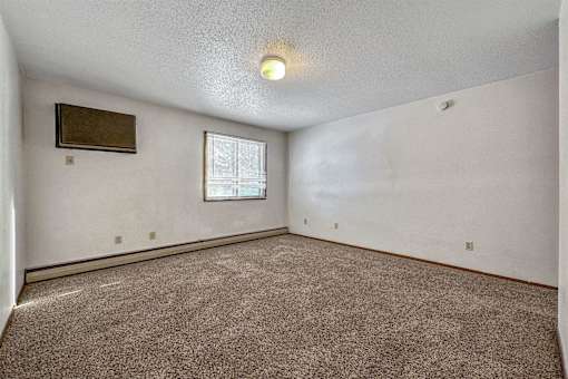 an empty living room with carpet and a window at Autumn Park, South Dakota, 57106
