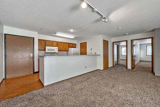 an empty living room with a kitchen with a counter top at Autumn Park, South Dakota  