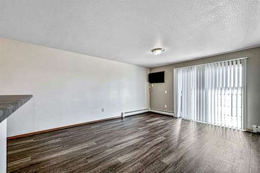 the living room and dining room of an apartment with wood flooring at Autumn Park, Sioux Falls  