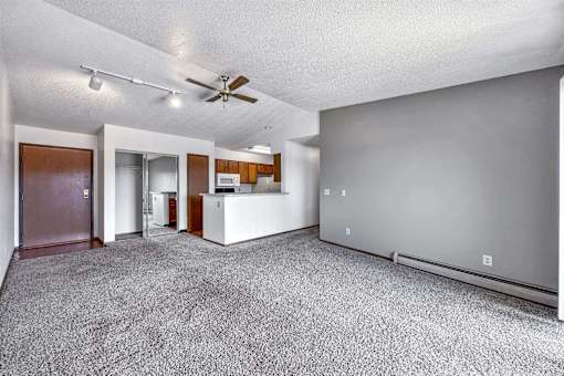 an empty living room with a ceiling fan and a kitchen at Autumn Park, Sioux Falls, SD  