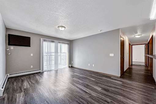 an empty living room with wood flooring and a sliding glass door at Autumn Park, South Dakota  