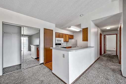 an empty kitchen with a counter top and a refrigerator at Autumn Park, Sioux Falls  