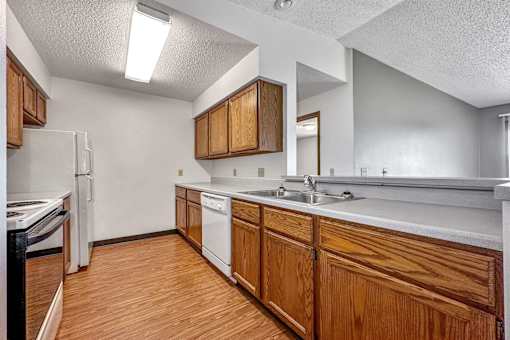 a kitchen with wooden cabinets and a sink and a refrigerator at Autumn Park, Sioux Falls, 57106  