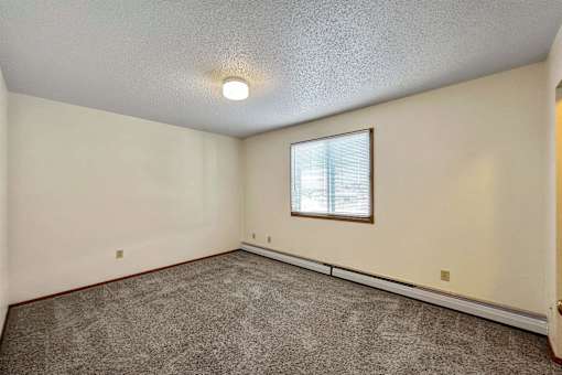 an empty living room with carpet and a window at Autumn Park, South Dakota  