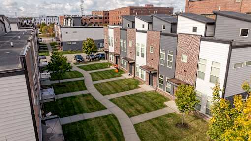 A view of a residential area with apartment buildings and a grassy area in the foreground.