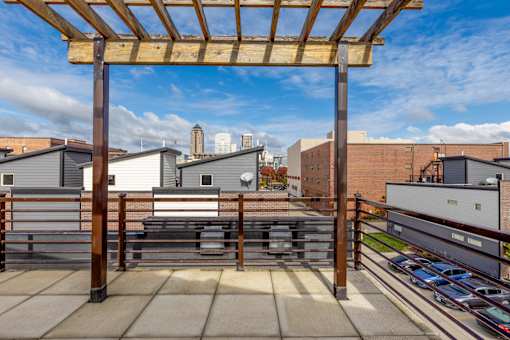 A wooden pergola is over a concrete patio.