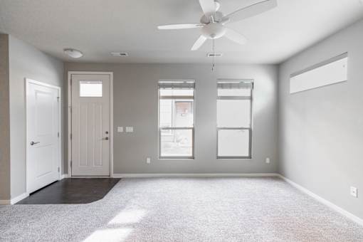 A room with a ceiling fan and a window.