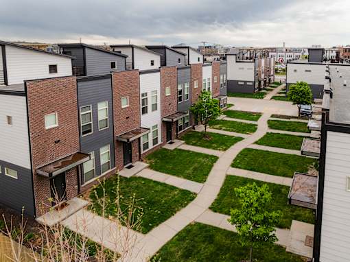 A row of modern townhouses with a pathway between them.