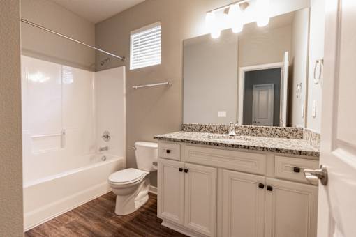A white bathroom with a toilet, sink, and shower.