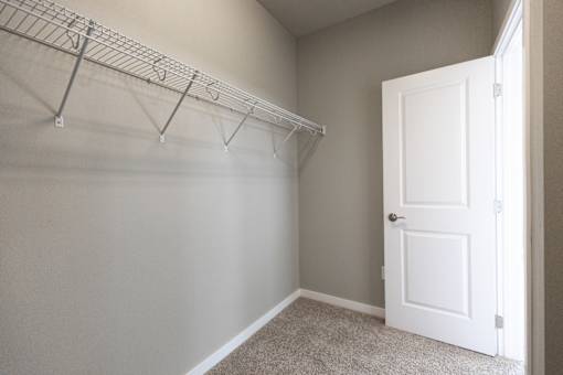 A white door is in a room with a white wall and a carpet.