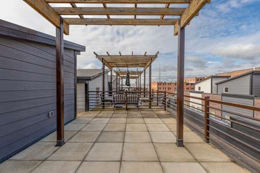 A patio with a pergola and a table set up for dining.